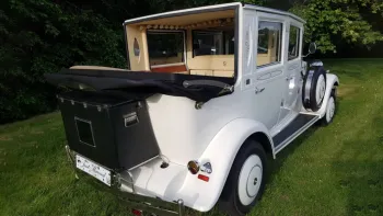 Rear view of White Imperial Convertible wedding car with black soft top roof down and black picnic trunk at the rear