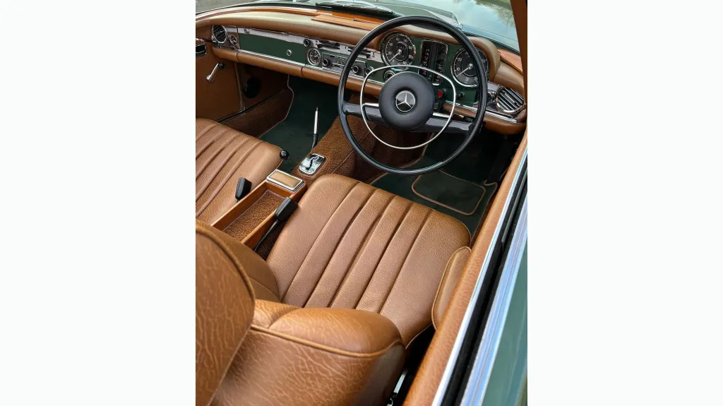 front driver seat and dashboard inside Classic Mercedes 280sl. Seats are Light tan leather with matching colour dashboard.