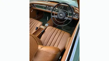 front driver seat and dashboard inside Classic Mercedes 280sl. Seats are Light tan leather with matching colour dashboard.