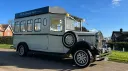 Vintage ivory bus with black wheel arches parked on the road