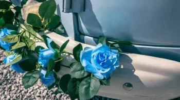 Blue Flowers with green foliage decoration attached to front bumper of Campervan