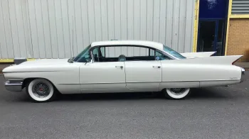 Left side view of white classic american Cadillac with white wall tires