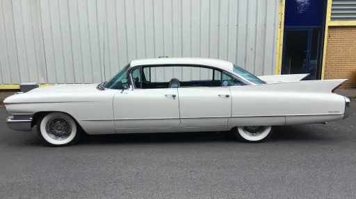 Left side view of white classic american Cadillac with white wall tires