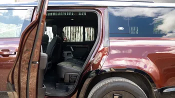 Rear left door open of a modern Land Rover Defender showing Black Leather interior