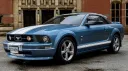 Front left side view of Blue Ford Mustang with convertible roof close.