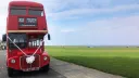Front view of red Double Decker Routemaster bus parked by the sea side in Tyne and Wear dressed with white wedding ribbons and bow