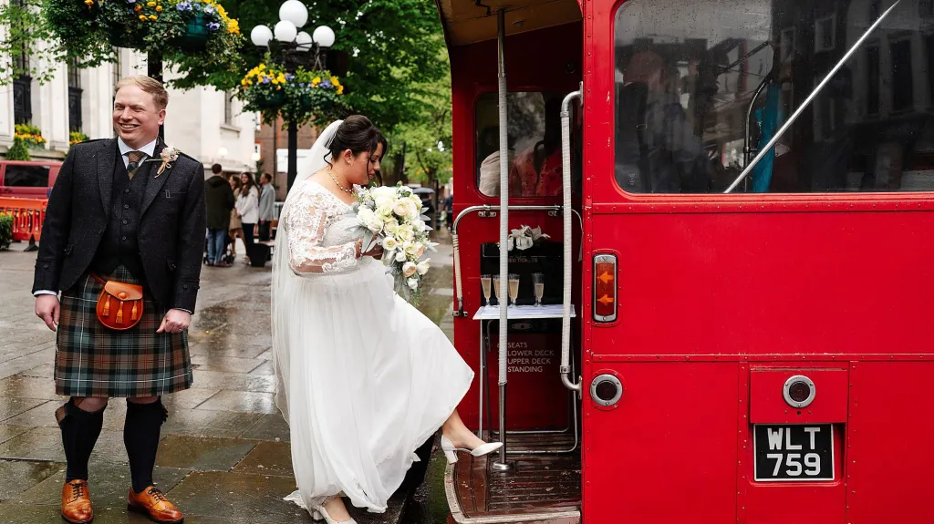 Bride boarding an old vintage routemaster bus through the rear open platform.