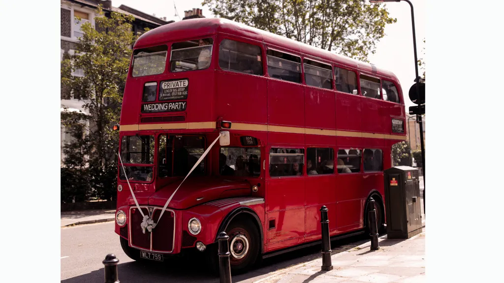Front left view of a Red London Routemaster bus decorqated with white ribbons parked in the street of London