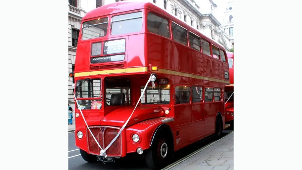 Front left view of Classic Red Routemaster London bus dressed with white ribbons