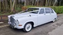 Classic daimler DS420 Limousine with wedding ribbons and large white wall tires.
