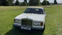 front view of classic Rolls-Royce Silver Spirit with large chrome grill and spirit of ecstasy seating a top