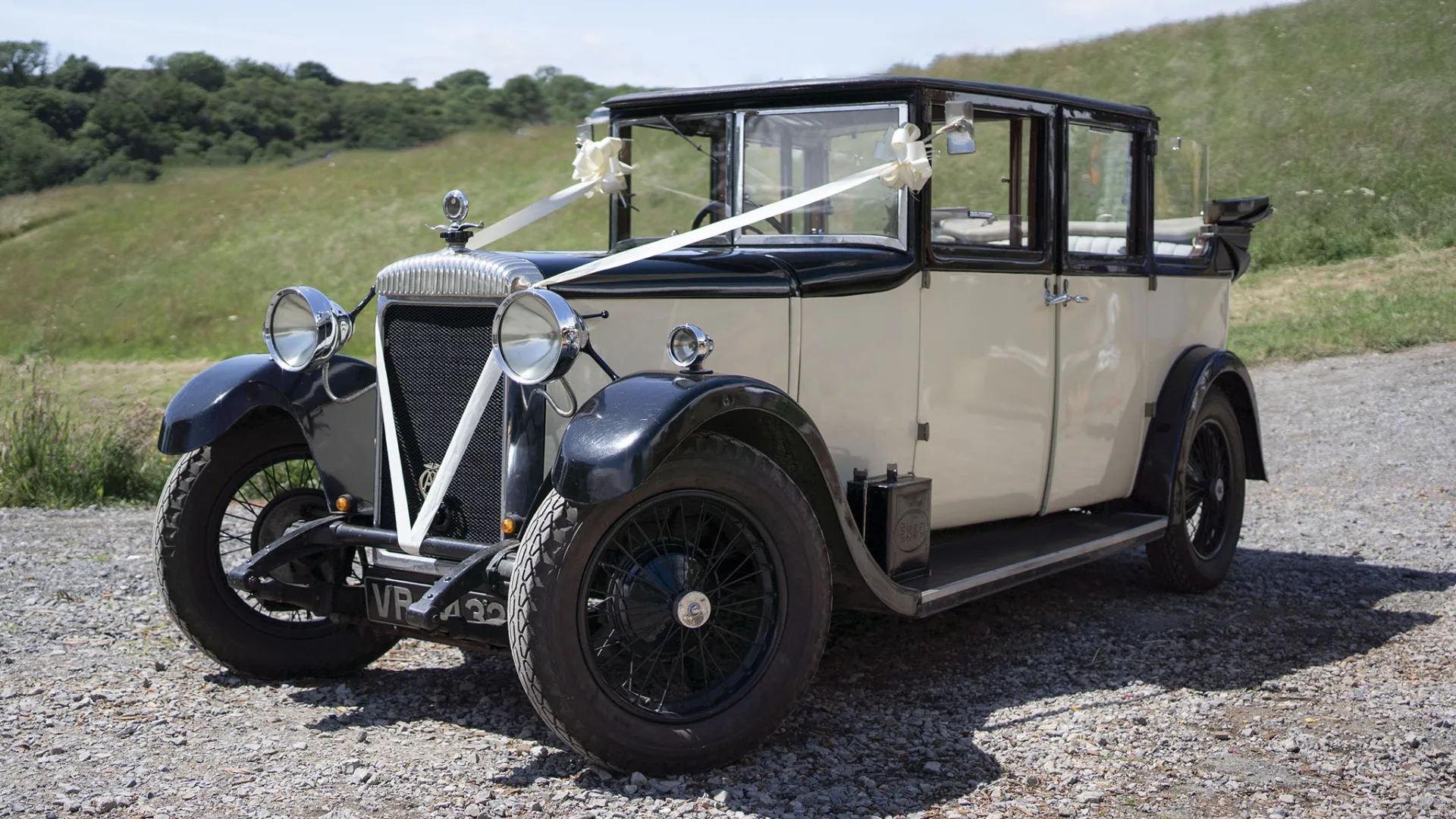 Vintage Daimler in Cream and Black decorated with White Wedding Ribbons and rear convertible roof open