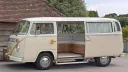 Left side view of a classic VW Campervan with rear door open and decorated with gold ribbons and bows