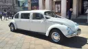 Classic Beetle in Ivory dressed with white ribbons parked in front of Registrar's office