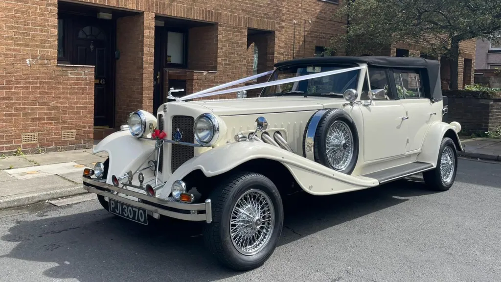 Vintage Beauford in Old English White with Black soft top roof and descorated with white wedding ribbons
