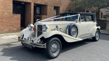 Vintage Beauford in Old English White with Black soft top roof and descorated with white wedding ribbons