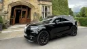 Left side view of a modern black range rover with white wedding ribbons and black alloy wheels