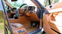 Front driver seat inside a Modern Bentley Flying Spur with Tan Leather interior