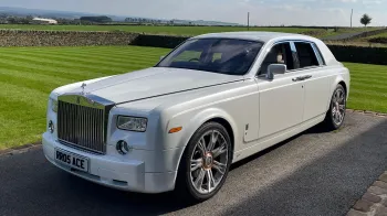 White Rolls-Royce Phantom with large alloy wheels and chrome front grill