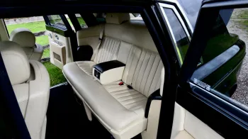 Black Rolls-Royce Phantom with door open showing cream leather rear seating area