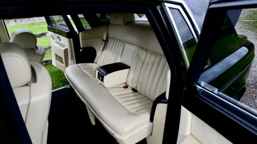 Black Rolls-Royce Phantom with door open showing cream leather rear seating area