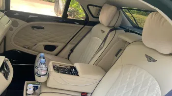 Rear interior cream leather seats with embroidered Bentley logo on the rear seats