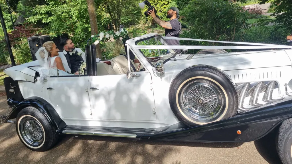 Bride and Groom seating on the rear bench seat inside convertible Beauford