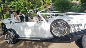 Bride and Groom seating on the rear bench seat inside convertible Beauford