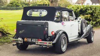 Vintage Beauford rear view of black picnic trunk with black soft top roof closed