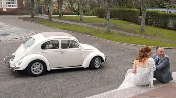 Right side view of Ivory Classic Volkswagen Beetle with Bride and Groom
