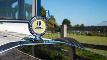 close-up view of car badge on top of the chrome grill