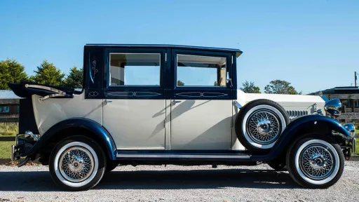 Right side view of a two-tonw Ivory and Metallic Blue Imperial with rear soft top roof open