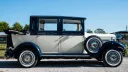Right side view of a two-tonw Ivory and Metallic Blue Imperial with rear soft top roof open