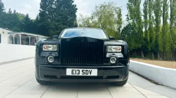 Black Rolls-Royce Phantom full front view with black chrome grill