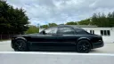 Black Rolls-Royce Phantom left side view showing black alloy wheels and privacy rear windows