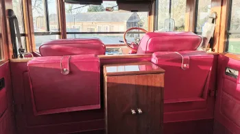 Rear interior cabing with casual seats rectracted and wooden cabinet in the middle