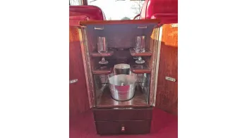 Vintage car interior wooden cabinet open showing a glass and bottle holder
