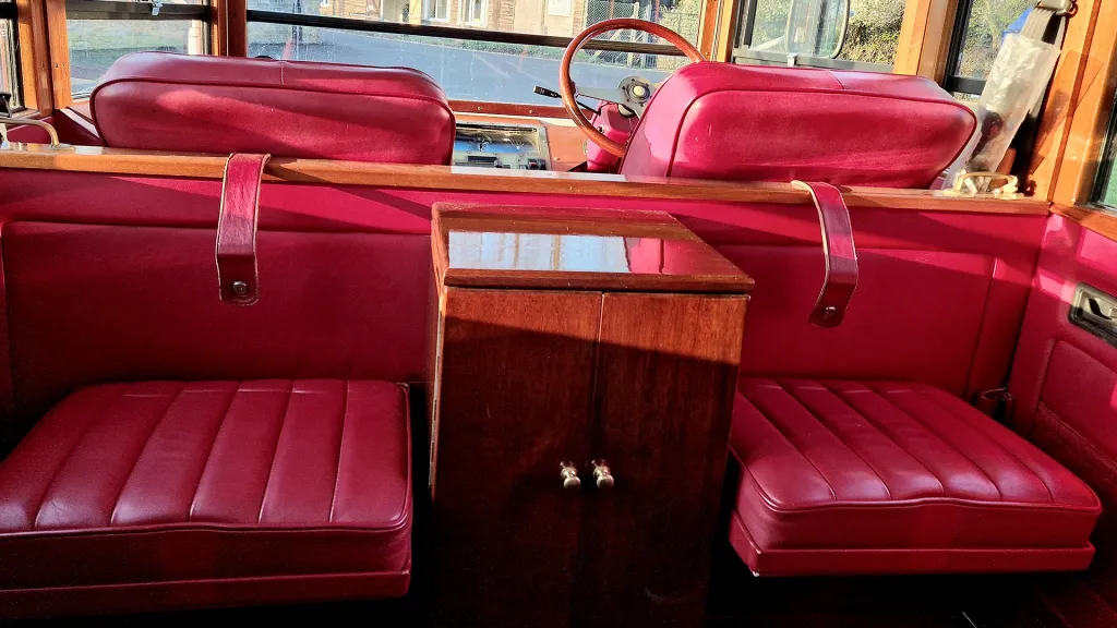 Rear interior cabin with casual seats open and wooden cabinet in the middle of the two spare seats