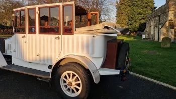 Rear view of  an Edwardian Style  Wedding Car with Semi-convertible roof open, spare wheel mounted at the rear of the vehicle