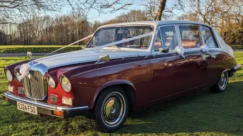 Burgundy & White Daimler Ds420 Limousine decorated with white wedding ribbons