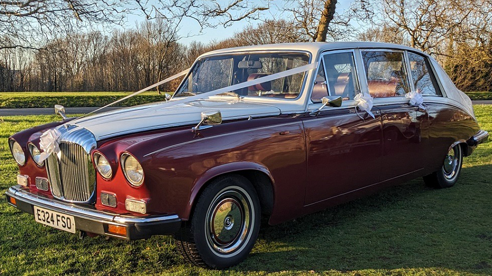 Burgundy & White Daimler Ds420 Limousine decorated with white wedding ribbons