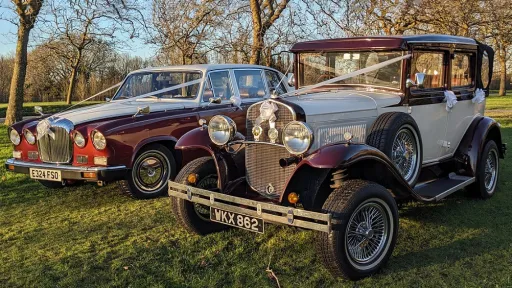 Two Matching Burgundy and White Wedding Cars. Right car is a vintage Badsworth and the left car is the Classic Daimler Limousine