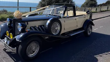 Ivory Beauford Convertible with Black Wheel Arches and Bonnet dressed with Ivory ribbons and a very large bow on top of the front radiator grill