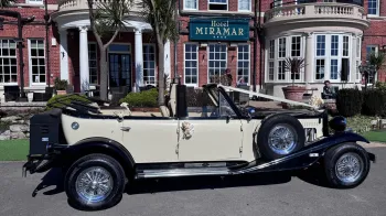 Right side view of Black and Ivory Beauford Convertible with roof down parked in front of the Miramar Hotel in Bournmemouth