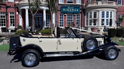 Right side view of Black and Ivory Beauford Convertible with roof down parked in front of the Miramar Hotel in Bournmemouth