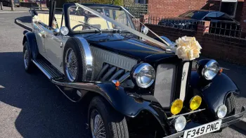 Front view of Vintage Beauford with a large Ivory bow on top of the Radiator