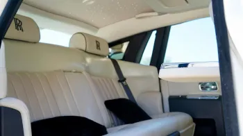 Rear interior seats inside Rolls-Royce Phantom. Cream leather seats with the RR logo emboided in the headrest.