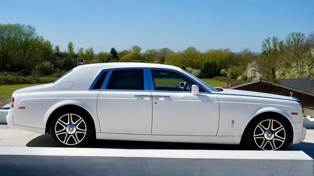 Right side view of White Rolls-Royce Phantom with doors closed, chrome alloy wheels