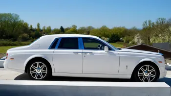 Right side view of White Rolls-Royce Phantom with doors closed, chrome alloy wheels