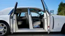 Right side view of White rolls-Royce Phantom with both front and rear coach doors open showing cream leather interior